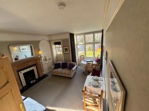 a living room with a table and a fireplace at St Giles Lodge in Inverness