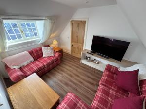 a living room with two couches and a flat screen tv at St Giles Lodge in Inverness