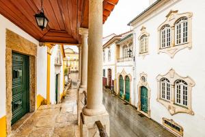 an alley in an old town with a green door at HI Lousã – Pousada de Juventude in Lousã