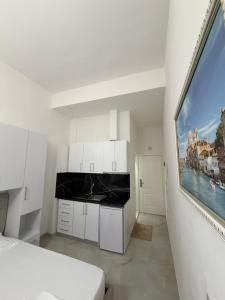 a bedroom with white cabinets and a large window at Xhani Boutique Rooms in Durrës