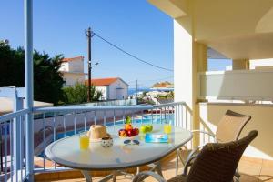 a table on a balcony with a bowl of fruit at Νηρηίδες Apartments Studios in Kyparissia