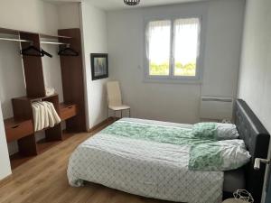 a bedroom with a bed and a window at Les camins in Hirel