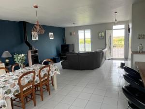 a living room with a table and a couch at Les camins in Hirel