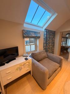 a living room with a couch and a flat screen tv at The stables at the Grange in York
