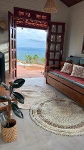 a bedroom with a bed and a view of the ocean at Vila do Sussurro - Casinha Céu in Triunfo