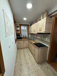 a kitchen with wooden cabinets and wooden floors at Székelyföld,Siklódi Kő Vendégház, Csűr in Şiclod