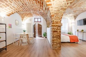 a bedroom with a brick wall and a bed and a table at Casa GAH Ripatransone Suite nel Borgo tra Mare e Calanchi in Ripatransone