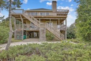 a large wooden house with a wooden stairway at 1067 - Easy Street in Corolla