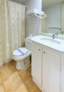 a white bathroom with a toilet and a sink at Apart Hotel Cambiaso in Santiago +83 photos
