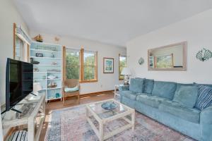 a living room with a blue couch and a tv at 3660 - Duckingham in Duck