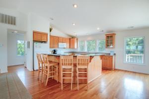 a kitchen with wooden cabinets and a kitchen island with bar stools at 3215 - Papa Duck in Duck +35 photos
