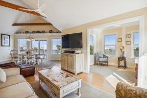 a living room with a couch and a tv at 3675 - Seaducktion in Duck +67 photos