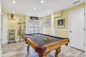 a pool table in a room with yellow walls at 3675 - Seaducktion in Duck