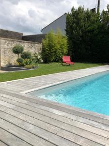 a swimming pool with a red bench next to a house at Maison En Ville in Niort +13 photos