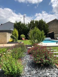 a garden with flowers and a swimming pool at Maison En Ville in Niort