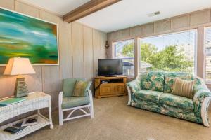 a living room with a couch and a tv at 4601 - Sandy Bluff in Southern Shores