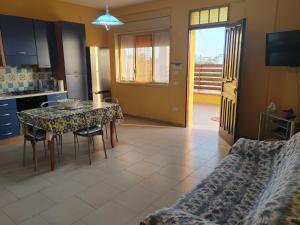 a kitchen and dining room with a table and chairs at Casa Mangiaracina in Porto Palo