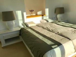 a bedroom with a bed and a desk with two lamps at Villa Olympia in Mesochórion