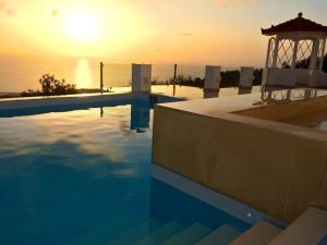 a swimming pool with a gazebo and the sunset at Villa Olympia in Mesochórion +19 photos