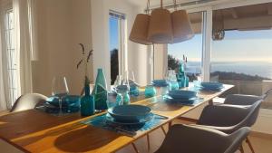 a dining room table with blue glass vases on it at Villa Olympia in Mesochórion
