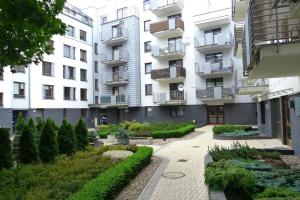 シュチェチンにあるSAS Apartamenty New Parkの庭園を正面に望むアパートメントビル