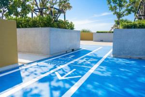 an outdoor basketball court with blue paint on the ground at Laguna Beachside residences apartamens, walking distance to the sea in Bang Tao Beach