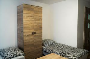 a bedroom with a wooden cabinet next to a bed at Przystań Baseny in Nowogród Bobrzański