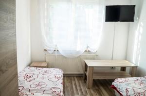 a room with two beds and a table and a window at Przystań Baseny in Nowogród Bobrzański