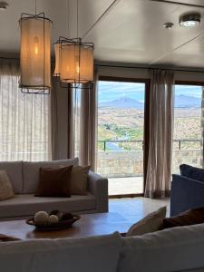 a living room with a couch and a large window at Hostería Varvarco in Varvarco