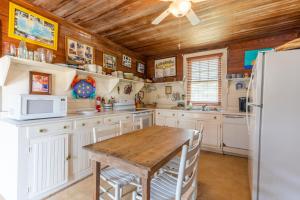a kitchen with white cabinets and a wooden table at 5441 - Rascoe in Nags Head