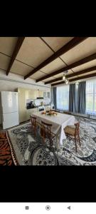 a dining room with a table and chairs and a kitchen at Guesthouse Chon - Kemin in Shabdan