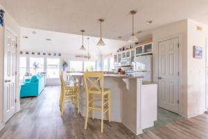 a kitchen with yellow stools at a kitchen counter at 4751 - Purple Passion in Kitty Hawk Beach