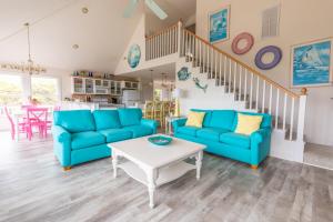 a living room with blue couches and a table at 4751 - Purple Passion in Kitty Hawk Beach