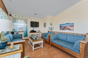a living room with blue couches and a tv at 4785 - Paradise Found in Kitty Hawk