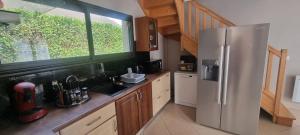 a kitchen with a stainless steel refrigerator and a window at La Résidence de Lorelei in Cierp