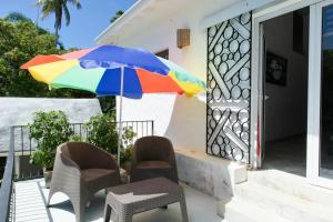 a colorful umbrella sitting on the porch of a house at NEW MORINGA in Las Terrenas