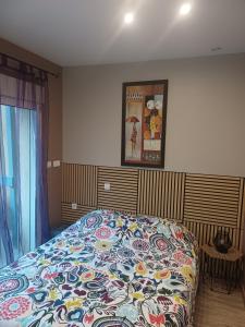 a bedroom with a bed with a colorful blanket at La Marceline Gîte avec piscine près de Lascaux IV in Aubas +20 photos