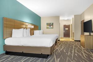 a hotel room with a bed and a flat screen tv at Best Western Plus Centralia Hotel & Suites in Centralia