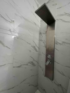 a bathroom with white marble walls and a shower stall at Studio apartment- private entry! in Homestead