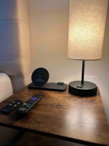 a table with a lamp and remote controls on it at Studio apartment- private entry! in Homestead