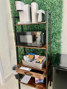 a shelf with a microwave and some food on it at Studio apartment- private entry! in Homestead
