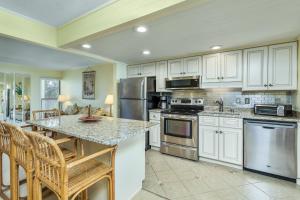 a kitchen with white cabinets and stainless steel appliances at 5695 - Pelican's Perch in Nags Head