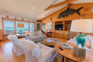 a living room with white furniture and a dolphin on the wall at 5451 - Richardson in Nags Head