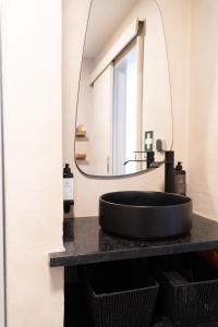 a bathroom with a black sink and a mirror at Praia das Maçãs Sea view Retreat in Colares +19 photos