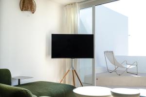 a living room with a tv and a couch and a chair at Praia das Maçãs Sea view Retreat in Colares