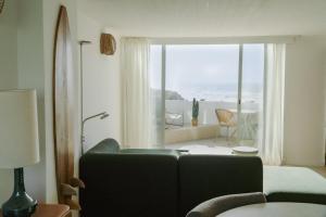 a living room with a couch and a view of the ocean at Praia das Maçãs Sea view Retreat in Colares