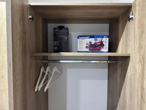 a cabinet with a box and utensils on a shelf at Hidden Apartment in Miercurea-Ciuc