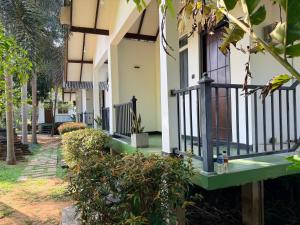 a house with a green balcony and trees at Greenfield Haven in Polonnaruwa +51 photos