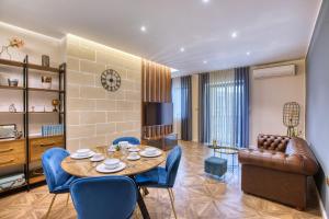 a living room with a table and chairs and a couch at NEW - Unique 3BR Apartment in Sought-After Area of Malta by SF Homes in Hal Ghaxiak