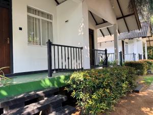 a front porch of a house with a green railing at Greenfield Haven in Polonnaruwa